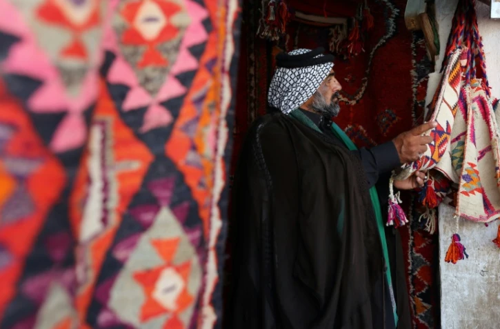 Le cheikh Hazem al-Hiyali regarde des tapis traditionnels dans une échoppe du marché des tapis, le 12 octobre 2017 à Hilla, en Irak