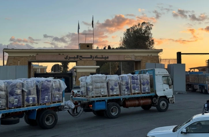 Des camions chargés d'aide humanitaire attendent du côté égyptien du poste-frontière de Rafah de pouvoir entre dans la bande de Gaza, le 15 octobre 2025