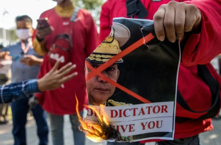 Des protestataires brûlent un portrait du chef de l'armée birmane, le général Min Aung Hlaing, devant le bureau des Nations Unies à Bangkok le 3 février 2021