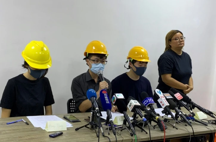 Trois membres du mouvement pro-démocratie, le visage couvert par un masque, donnent une conférence de presse "par le peuple, pour le peuple", le 6 août 2019 à Hong Kong