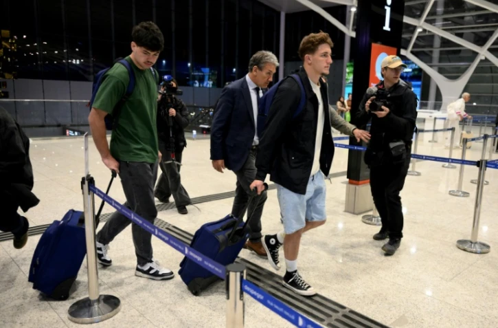 Les rugbymen français Hugo Auradou (g) et Oscar Jegou (2e à d) et leur avocat Rafael Cuneo Libarona (c), marchent avant de prendre un vol pour la France à l'aéroport d'Ezeiza, dans la province de Buenos Aires, en Argentine, le 3 septembre 2024