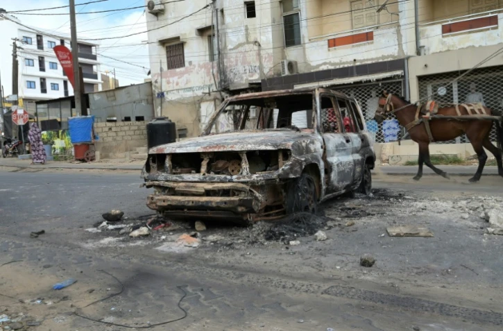 L'épave calcinée d'une voiture dans une rue de Dakar au lendemain d'affrontements, le 3 juin 2023 au Sénégal