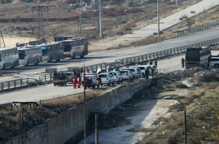 Véhicules de la Croix Rouge internationale et du Croissant Rouge Syrien à un point de passage le 18 décembre 2016 à Ramoussa dans la banlieue sud d'Alep