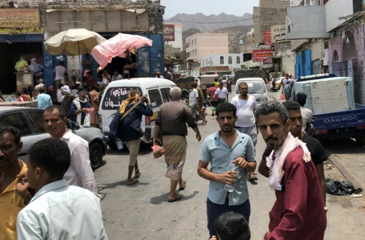 Des Yéménites marchent dans un marché à Aden deuxième ville du pays tenue par le gouvernement yéménite, le 11 août 2019, à la suite d'affrontements entre les forces progouvernementales et des séparatistes sudistes