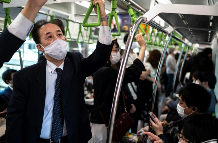 Des personnes dans un train à Tokyo le 23 avril 2021, avant la déclaration d'un nouvel état d'urgence lié au coronavirus qui devrait couvrir plus tard dans la journée les régions de Tokyo, Osaka, Kyoto et Hyogo.