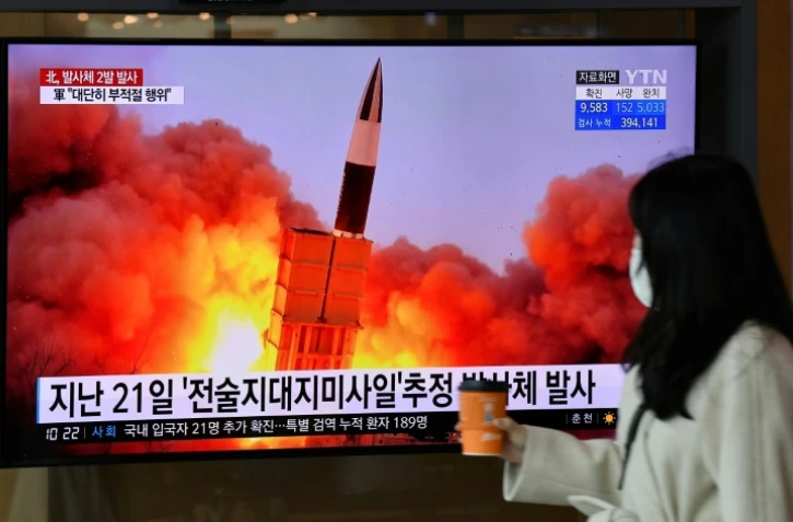 Une femme passe devant un écran de télévision diffusant des images d'un tir de missile nord-coréen, le 29 mars 2020 dans une gare de Séoul, en Corée du Sud