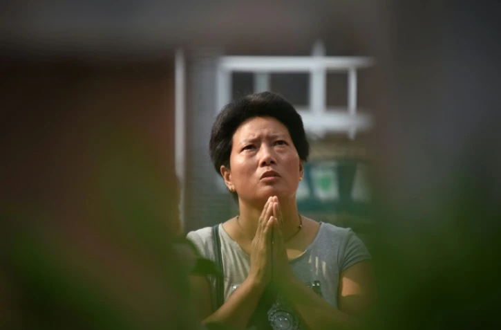 Une croyante prie pendant une messe dans la cathédrale catholique d'Anyang en Chine, le 12 août 2018