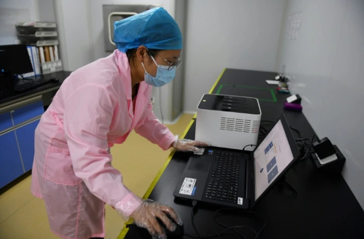 Une technicienne vérifie les résultats d'un test en utilisant le Flash 20, une machine conçue par l'entreprise chinoise de biotechnologie Coyote pour réaliser des
dépistages rapides au nouveau coronavirus, le 27 septembre 2020 à Pékin