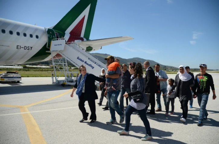 Des familles de réfugiés syriens embarquent à bord de l'avion du pape le 16 avril 2016 à l'aéroport de Mytilène