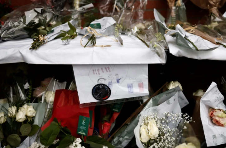 Des fleurs déposées devant le commissariat de Roubaix en hommage aux trois policiers morts la veille dans un accident de la route, le 22 mai 2023 dans le Nord
