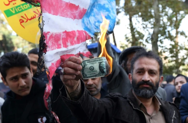 Un Iranien brûle un dollar lors d'une manifestation le 4 novembre 2018 à Téhéran marquant le 39e anniversaire de l'occupation de l'ambassade américaine