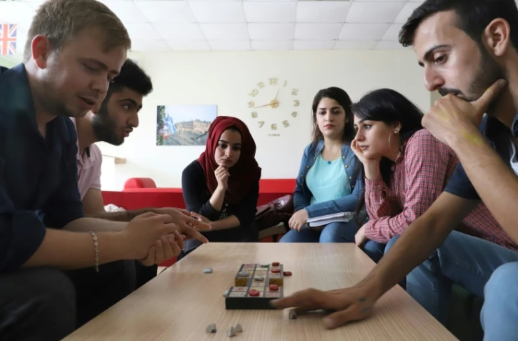 Hochmand Mofaq et l'archéologue britannique Ashley Barlow (g) jouent au Jeu royal d'Ur, le 22 octobre 2018 à Raniye, en Irak