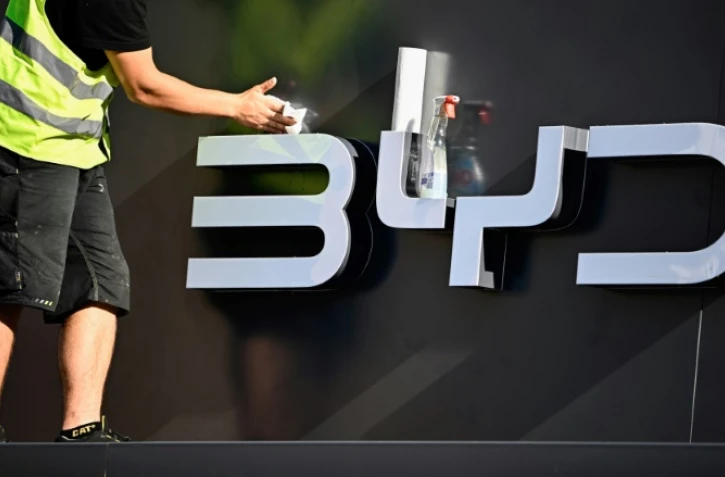 Un employé nettoie le logo du constructeur automobile chinois BYD au salon de l'automobile de Munich le 4 septembre 2023