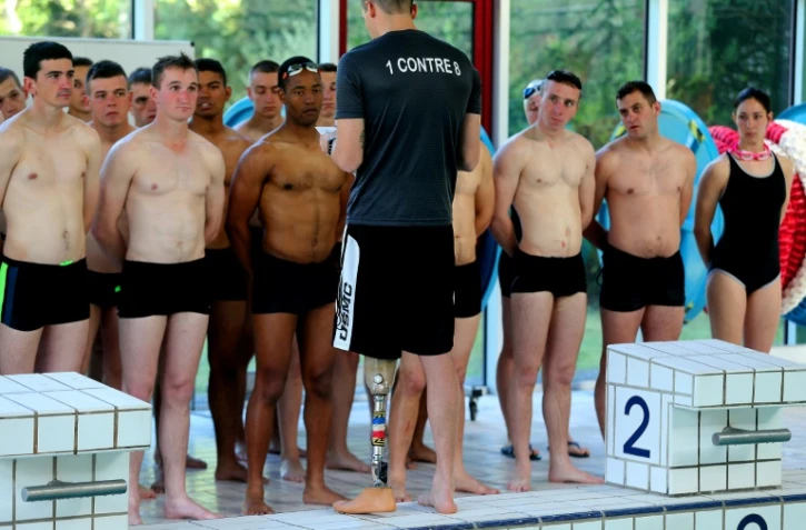 Le caporal-chef Benjamin, aide-moniteur au 132e bataillon cynophile de l'Armée de terre à Suippes, entraîne des soldats, à la piscine de Suippes, le 13 juin 2019
