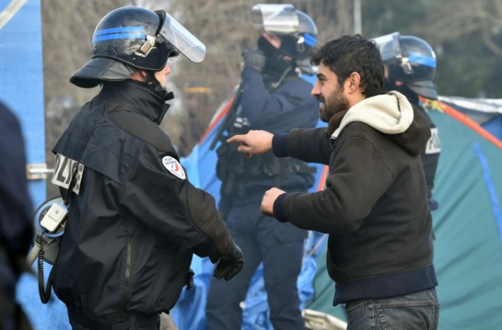Un migrant face à un policier, le 29 février 2016 lors des opérations de démantèlement dans le camp de la "jungle" à Calais