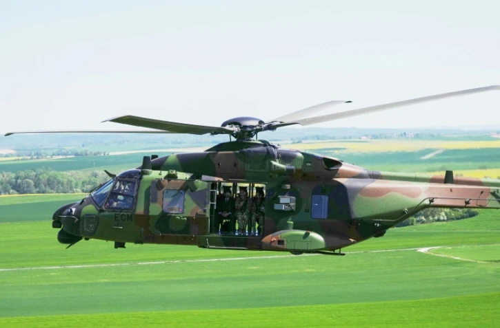 Le président français Emmanuel Macron (G) à bord d’un hélicoptère NH90 Caïman lors des manœuvres militaires Orion 2026 sur un camp à Suippes, dans l’est de la France, le 30 avril 2026
