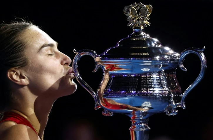 La joueuse de tennis bélarusse Aryna Sabalenka embrasse la coupe Daphne Akhurst Memorial après sa victoire en finale de l'Open d'Australie contre la Chinoise Zheng Qinwen à Melbourne le 27 janvier 2024