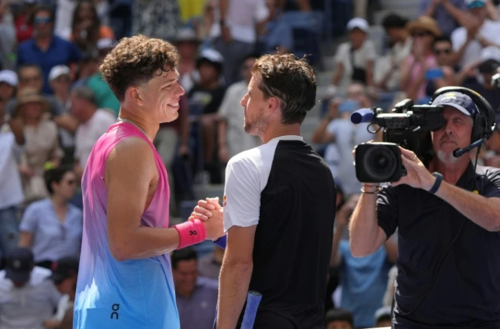 L'Américain Ben Shelton (g.) serre la main de l'Autrichien Dominic Thiem après sa victoire au premier tour de l'US Open, à New York, le 26 août 2024