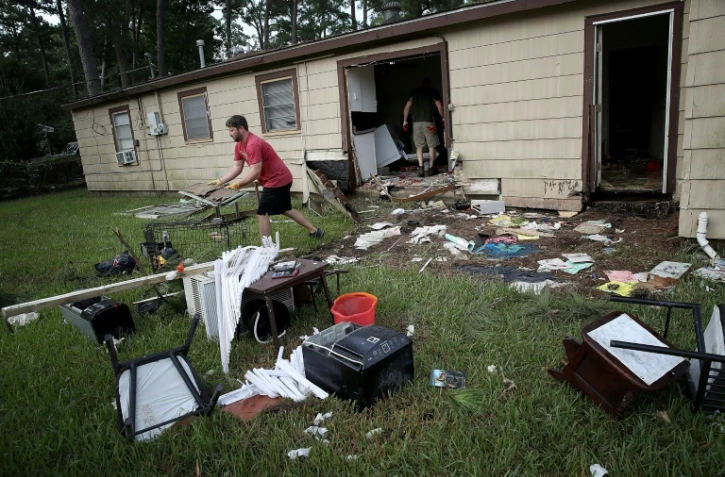 Chris Gaspard sort des meubles abimés par les inondations de la maison de son ami Bryan Parson le 1er spetmbre 2017 à Dickinson, Texas