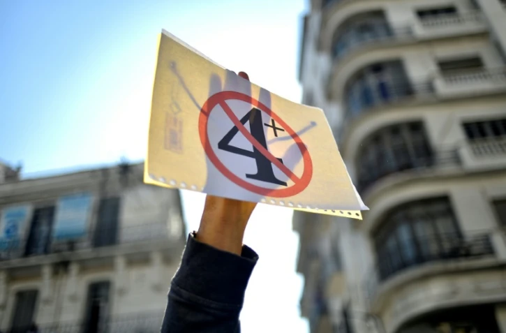 Un étudiant algérien brandit un "4+" barré en signe de protestation contre la prolongation du 4e mandat du président Abdelaziz Bouteflika, le 12 mars 2019 à Alger