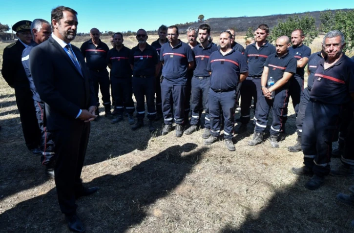 Le ministre de l'Intérieur  Christophe Castaner (G) rencontre les pompiers mobilisés sur les incendies dans le Gard, le 3 août 2019 à Générac
