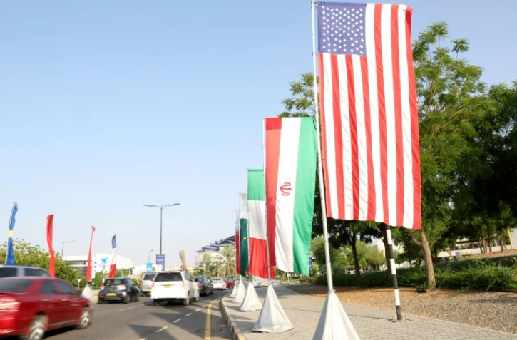 Des drapeaux américains et iraniens le long d'une route à Mascate, le 25 avril 2025 au sultanat d'Oman
