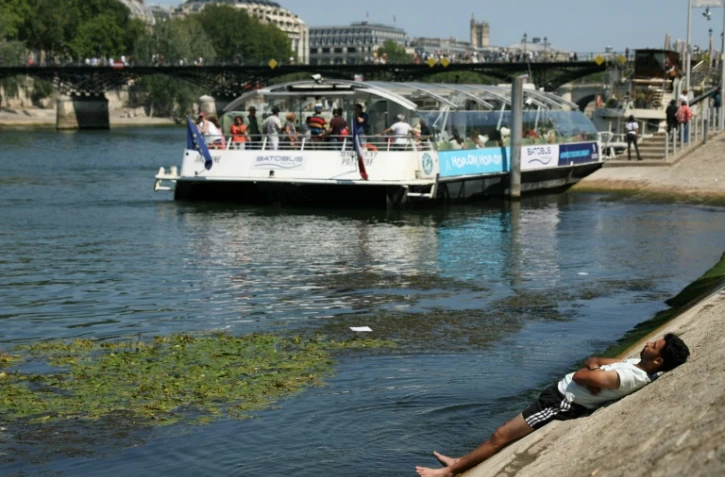 Un homme se rafraîchit sur une berge de la Seine, à Paris, alors qu'une vague de chaleur frappe la France, le 19 juin 2025