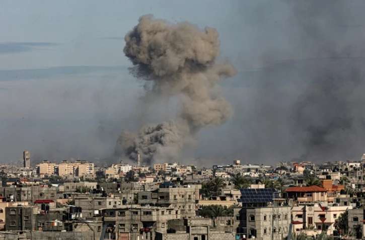 De la fumée s'élève au-dessus de Khan Younès, le 13 janvier 2024, vu depuis Rafah dans la bande de Gaza