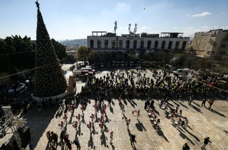Une parade de scouts sur la place de la Mangeoire, devant la basilique de la Nativité à Bethléem, le 24 décembre 2025 en Cisjordanie occupée