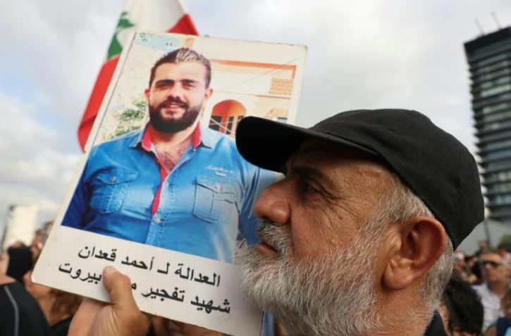 Un manifestant brandit le portrait d'une victime de la catastrophique explosion qui a ravagé le port de Beyrouth en 2020, lors d'une manifestation de commémoration et pour réclamer la punition des responsables, à Beyrouth, le 4 août 2025