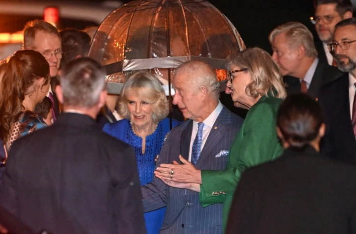 Le roi Charles III (au centre à droite) et la reine Camilla (au centre à gauche) sont accueillis à leur arrivée à l'aéroport international de Sydney vendredi 18 octobre 2024