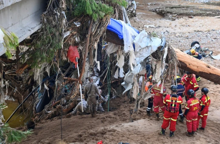 Des militaires espagnols et des pompiers portugais recherchent des victimes le long d'une rivière quatre jours après des inondations dévastatrices, le 2 novembre 2024 à Paiporta, dans la région de Valence, en Espagne