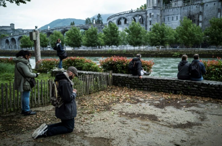 Des pèlerins devant la basilique Notre-Dame du Rosaire avant la réouverture du sanctuaire de Lourdes, fermé pour la première fois de son histoire pendant deux mois, pour cause d'épidémie, le 16 mai 2020 à Lourdes