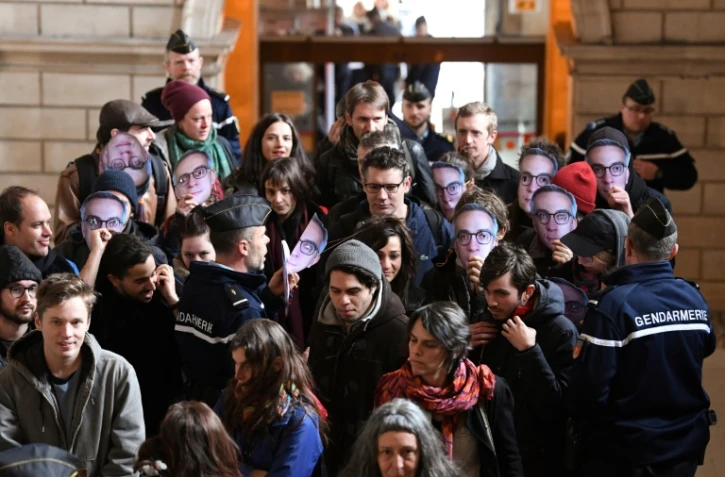 Des prévenus portant un masque de Julien Coupat arrivent au tribunal correctionnel de Paris pour l'ouverture du procès du "groupe de Tarnac", le 13 mars 2018