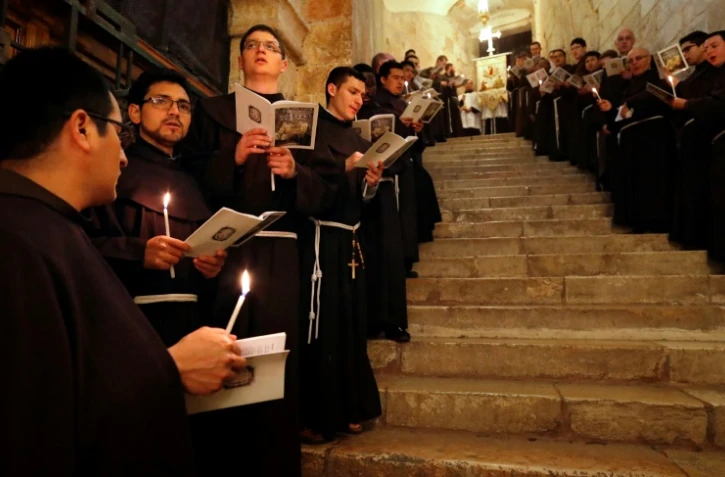 Des moines franciscains chantent au cours d'une procession dans l'église du Saint Sépulcre à Jérusalem, le 17 février 2018
