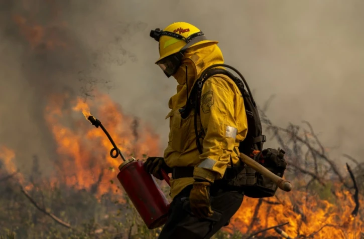 Un pompier allume un contrefeu pour stopper l'avancée de l'incendie Oak Fire, près de Mariposa (Californie), le 24 juillet 2022