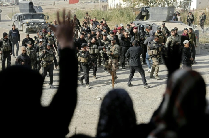 Des membres des forces spéciales irakiennes accueillis par la population dans un quartier de Mossoul repris aux jihadistes, le 27 novembre 2016 en Irak