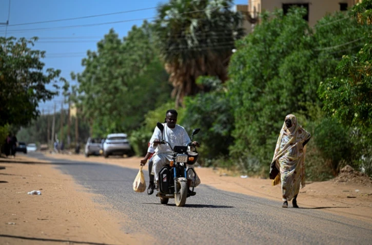 Un bénévole soudanais chargé de livrer des médicaments à domicile roule en moto à Khartoum, le 18 avril 2026
