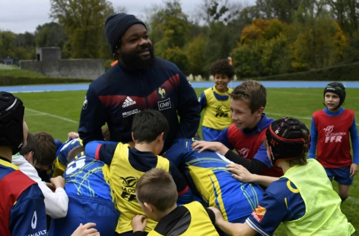 Le centre du XV de France Mathieu Bastareaud entouré d'enfants d'un club de rugby au centre d'entraînement de Marcoussis, le 4 novembre 2017 