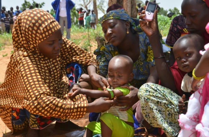 Au Niger, les mères utilisent un périmètre brachial (PB), un brassard tricolore, qui sert à mesurer l'épaisseur du bras et détecter la malnutrition, dans le village de Barago (sud), le 14 juillet 2016 