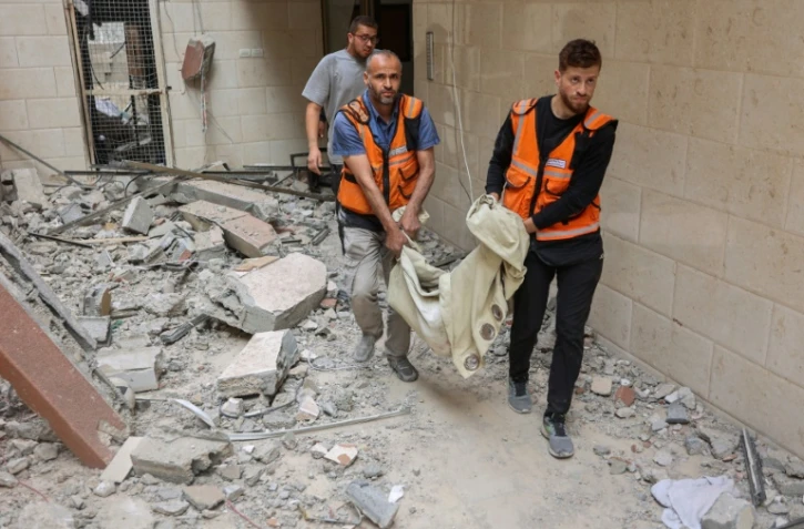 Des secouristes palestiniens évacuent le corps d'une victime d'une frappe israélienne sur un immeuble de la ville de Gaza, dans le nord du territoire palestinien, le 24 avril 2025