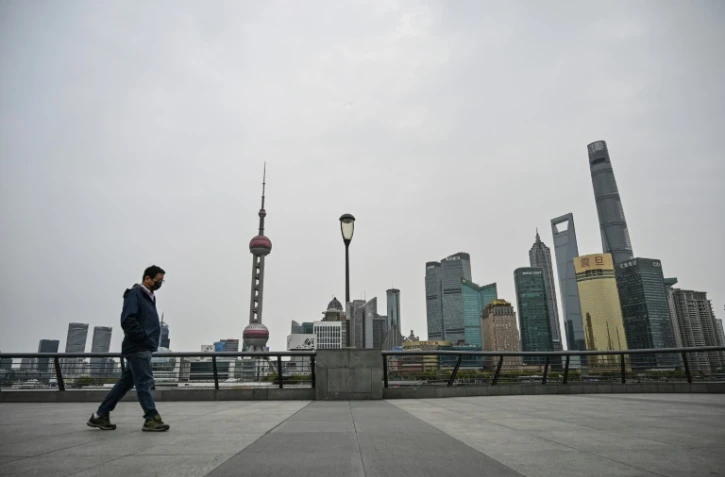 Un homme marche sur le Bund, artère historique de Shanghai le 28 mars 2022