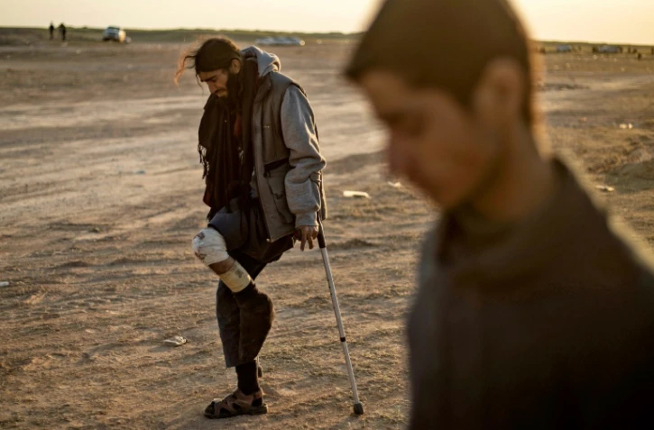 Un homme blessé soupçonné d'être un combattant du groupe Etat islamique sort du dernier réduit du groupe jihadiste à Baghouz dans l'est de la Syrie, le 6 mars 2019