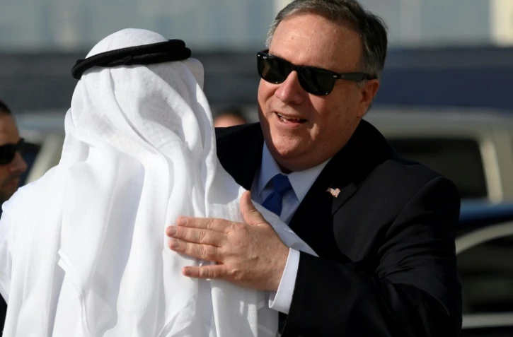Le secrétaire d'Etat américain Mike Pompeo (D) salue l'ambassadeur émirati aux Etats-Unis, Youssef al Otaiba, lors d'une visite à Abou Dhabi, étape de sa tournée au Moyen-Orient, le 13 janvier 2019