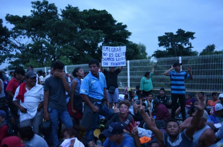 Des migrants honduriens en route vers les Etats-Unis se reposent à la fontière avec le Mexique, le 19 octobre 2018 à Tecun Uman, au Guatemala