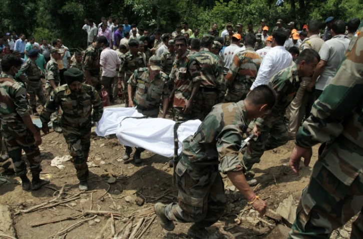 Des soldats de l'armée indienne recherchent des survivants après un glissement de terrain le long d'une route à Kotrupi, à environ 200 kilomètres de la capitale de l'état de Himachal Pradesh, le 13 août 2017