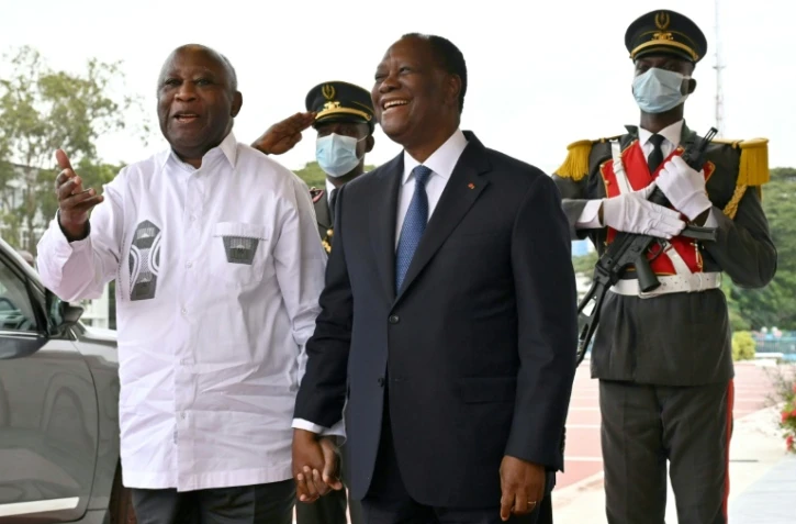 Le président ivoirien Alassane Ouattara (c) et son prédécesseur Laurent Gbagbo (g), à Abidjan, le 27 juillet 2021