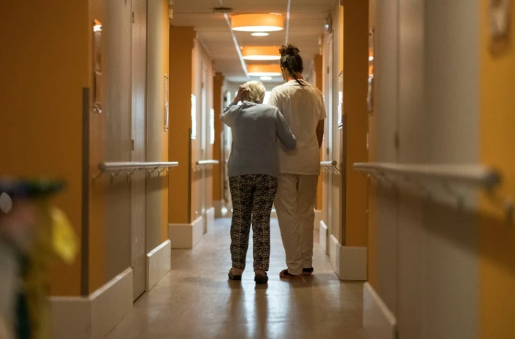 Un personnel soignant de l'Ehpad de Vill'Alize (groupe Korian) assiste une personne âgée à Thise (Doubs), le 16 avril 2020
