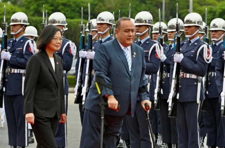 La présidente taïwanaise Tsai Ing-wen et son homologue guatémaltèque Alejandro Giammattei passent en revue la garde d'honneur, le 25 avril 2023 à Taipei