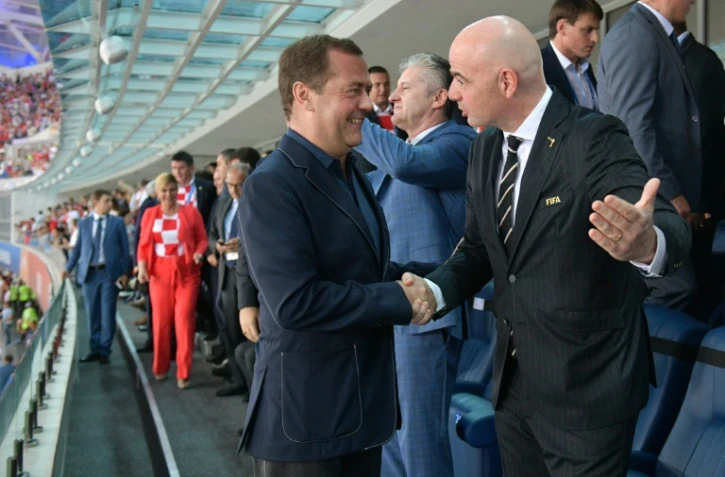 Le président de la Fifa Gianni Infantino (d) serre la main du Premier ministre russe Dmitry Medvedev lors de Russie-Croatie au Mondial, le 7 juillet 2018 à Sotchi